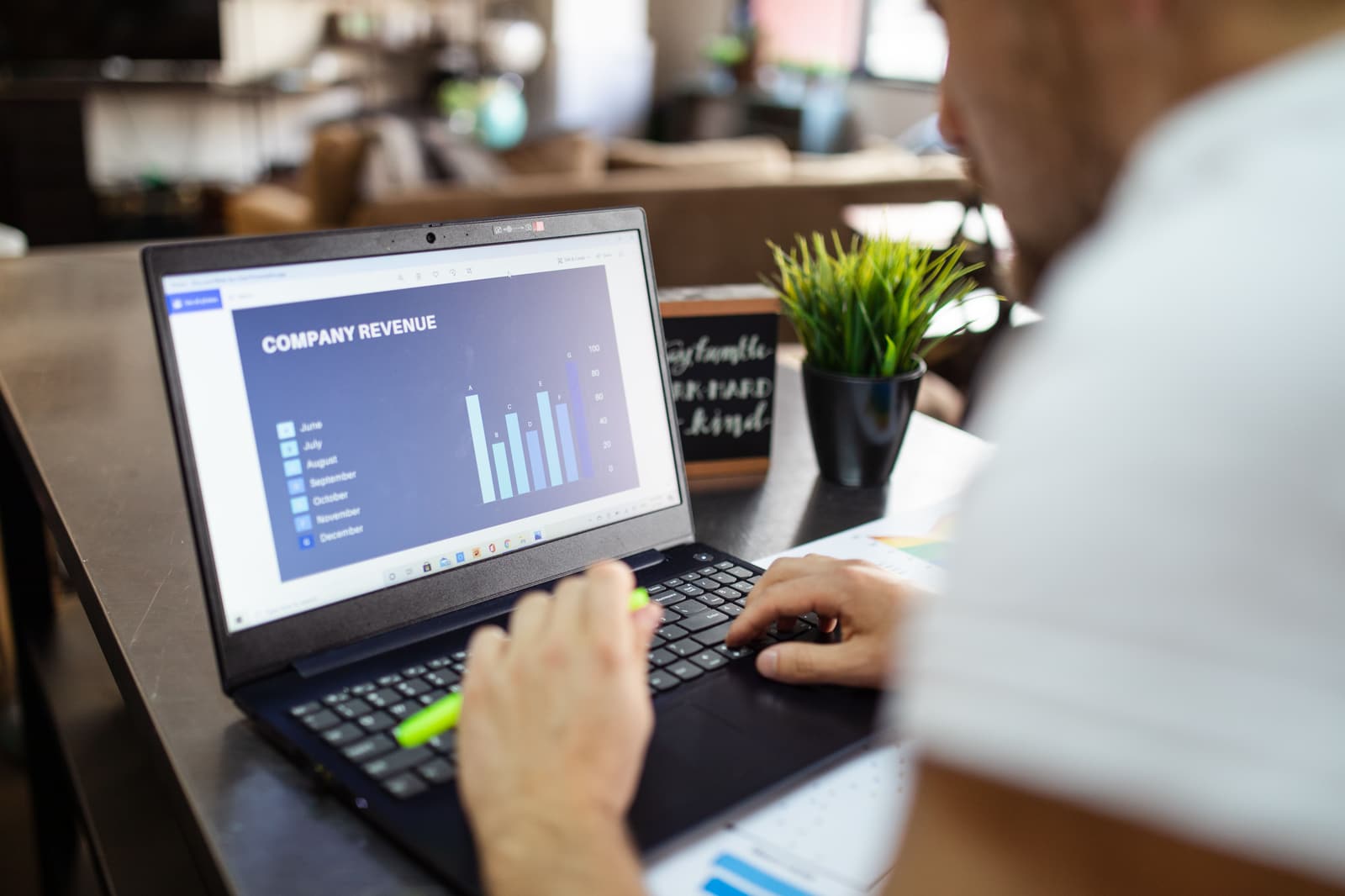 A business owner reviewing company revenue on a laptop