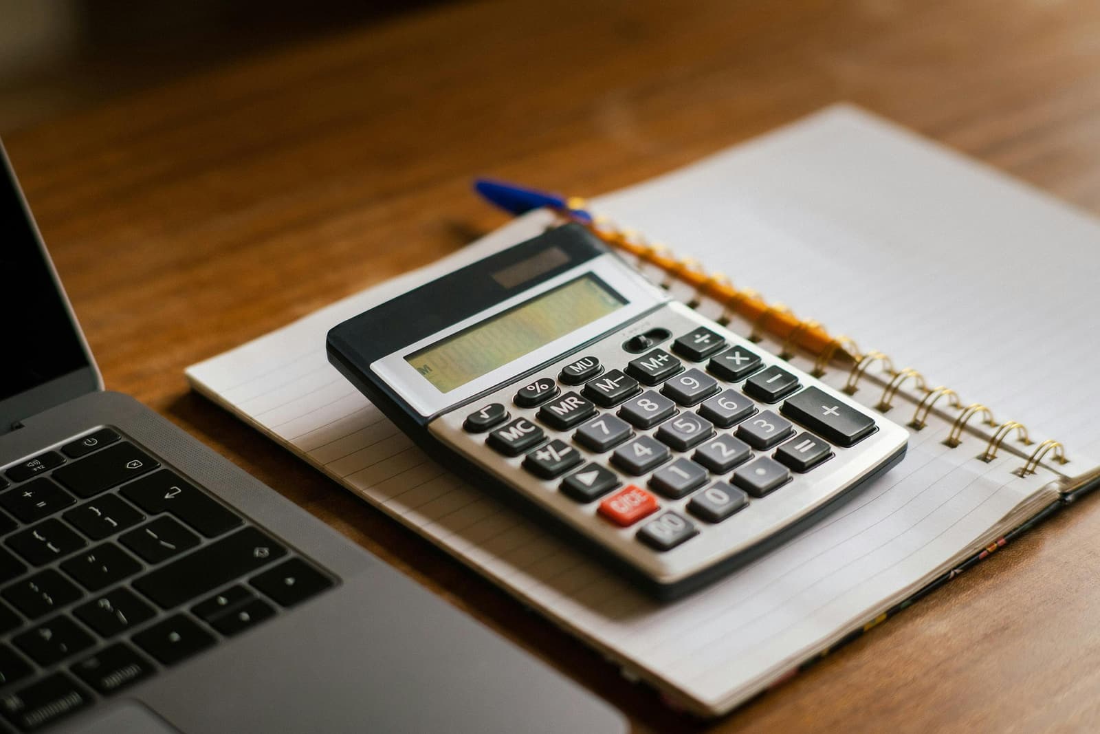 A calculator and laptop during year-end close